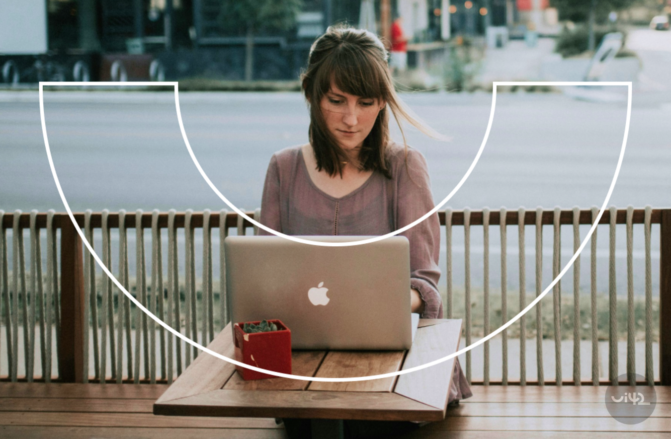 A woman working on a laptop on an outdoor terrace
