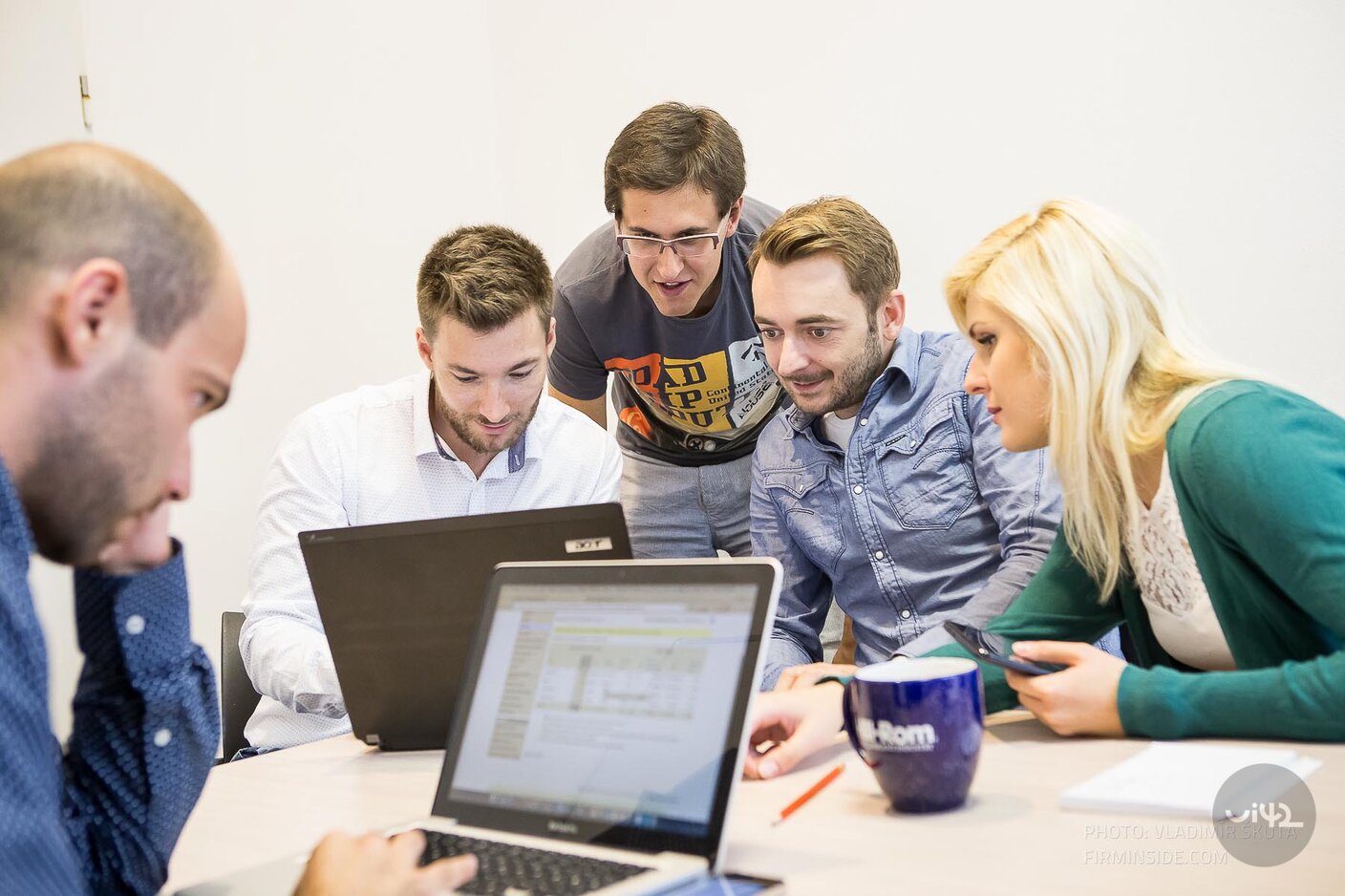A group of people working on UX testing at a table with laptops